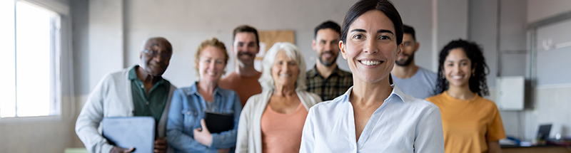 Group of teachers standing in a classroom smiling at the camera