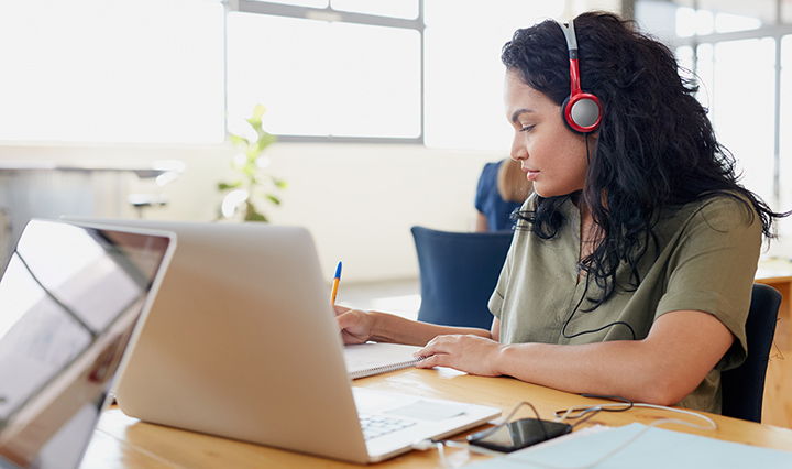 woman listening to headphones at work